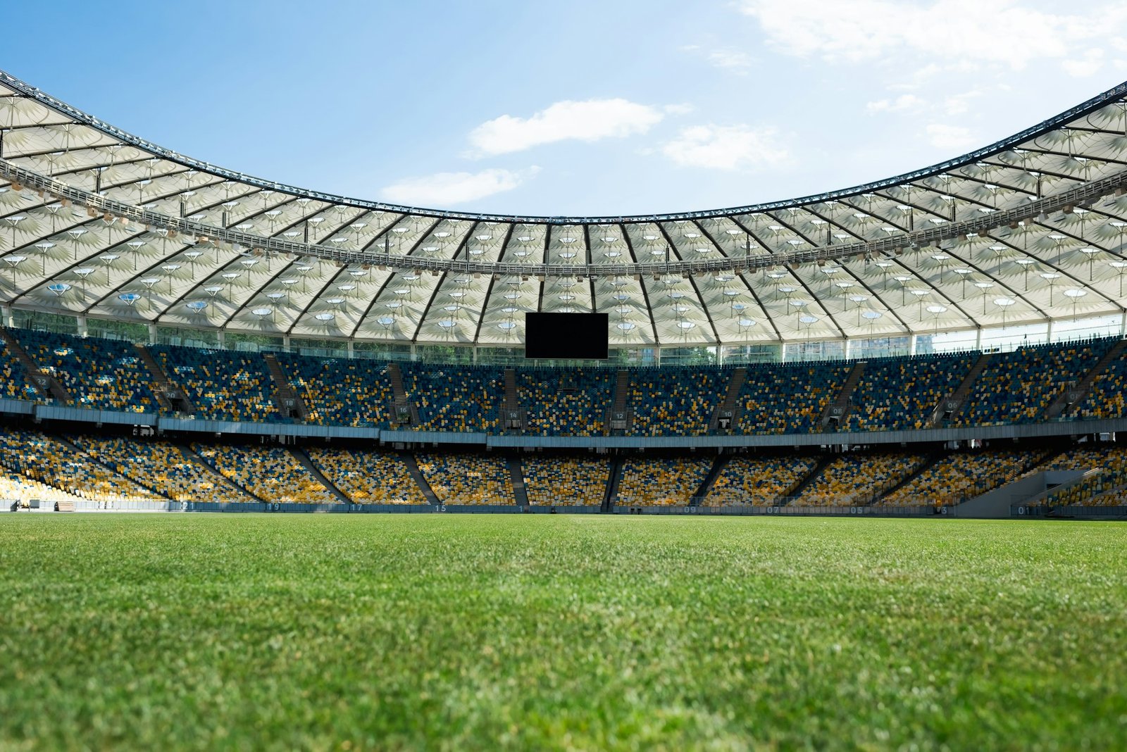 grassy football pitch at stadium at sunny day with blue sky